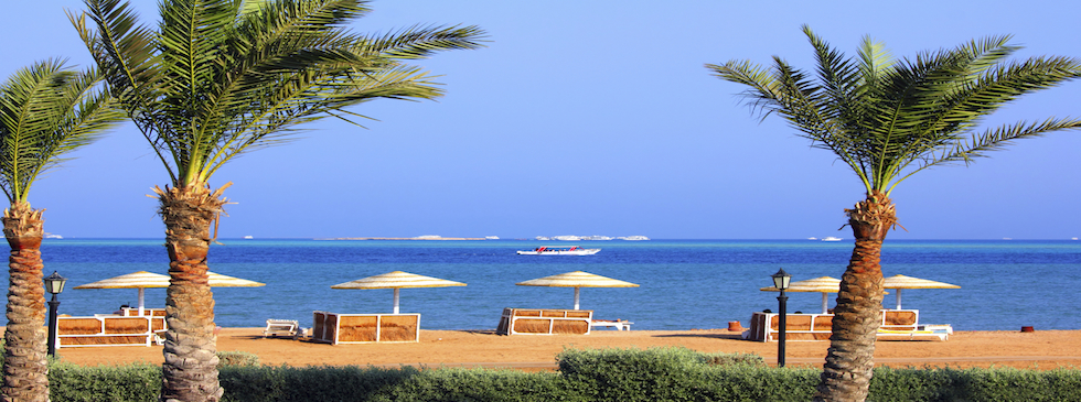 El Gouna sea side view with sandy beach, blue sea water and green palm trees