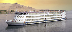 a white cruise ship in the Nile river with the Sun setting view behind the mountains